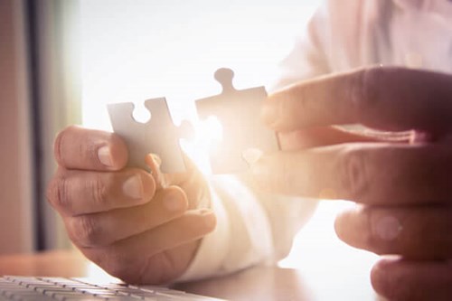 person putting puzzle pieces together 